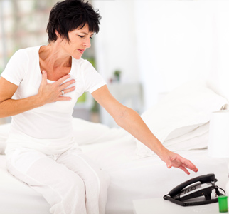 Woman holding one hand to chest and reaching for the phone